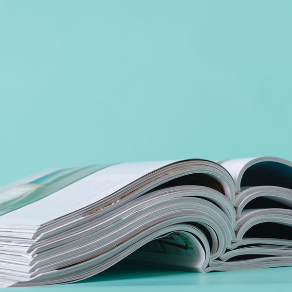 Stack of open magazines on a table